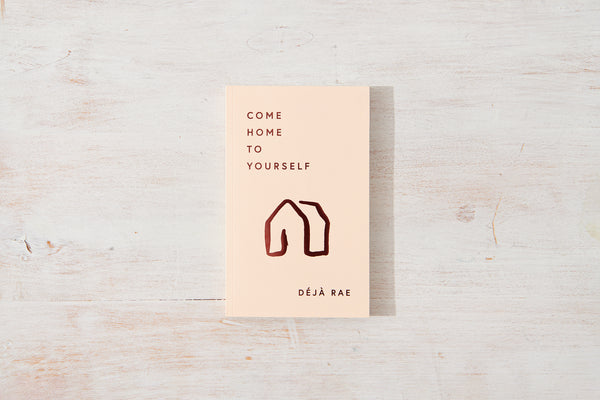 A piece of paper with the words "Come Home to Yourself" on it, reminding individuals to find solace in solitude and prioritize their relationships with design and lifestyle books as their guide, from the brand Thought Catalog, by Déjà Rae.