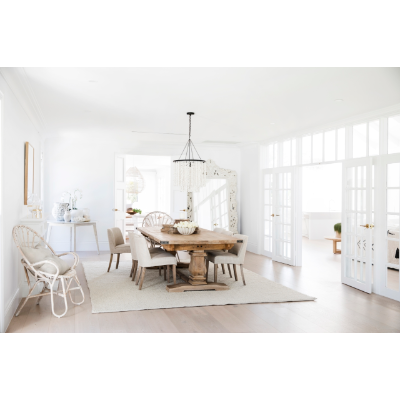 A white dining room with a wooden table and chairs perfect for Instagram and YouTube-renovators, featuring the Three Birds Renovations - 400+ Renovation and Styling Secrets Revealed book.