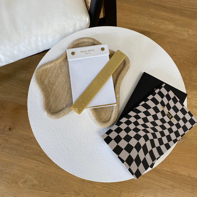 A sustainability-conscious notepad on a Papier HQ TRAVERTINE CURVED TRAY.