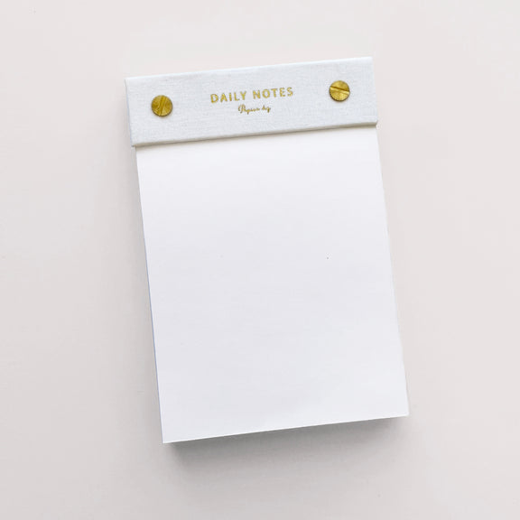 A limited edition white Daily Notes notepad embellished with gold studs, perfect for all your stationery needs by Papier HQ.
