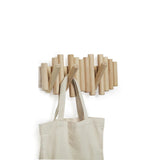 A Umbra wooden coat rack featuring a tote bag hanging on the Picket Rail Five Hooks.