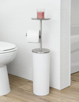 A bathroom with the Umbra Portaloo Toilet Paper Stand - White/Nickel and a candle, featuring bathroom appliances.