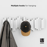 This Umbra wall coat rack, the Sticks Multi Hook - White, features multiple flip-down hooks for home organization.