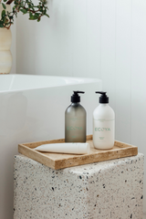 A sustainable bathroom showcasing green towel and Ecoya's Fragranced Hand & Body Lotion, perfect for home fragrance enthusiasts.