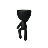 A black Wall Egg Head Planter figurine by Flux Home standing on a white background.