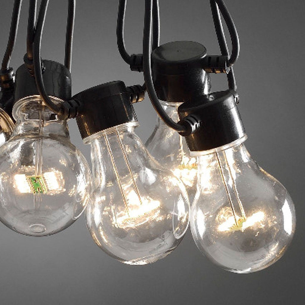 Weatherproof festoon lights strung along a fence line