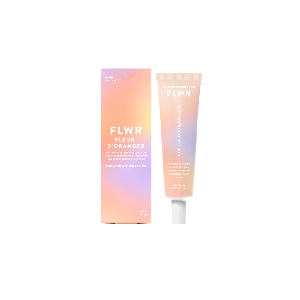 FLWR Fleur D'Oranger hand cream tube standing beside its peach and lilac gradient carton on white