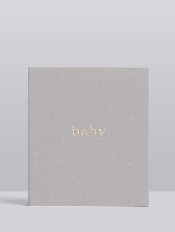 A Write To Me linen-bound BABY | YOUR FIRST FIVE YEARS journal with the word baby on it.