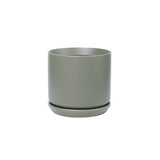 A small grey Medium Oslo Planter Sage by Potted on a white background with matching saucer.
