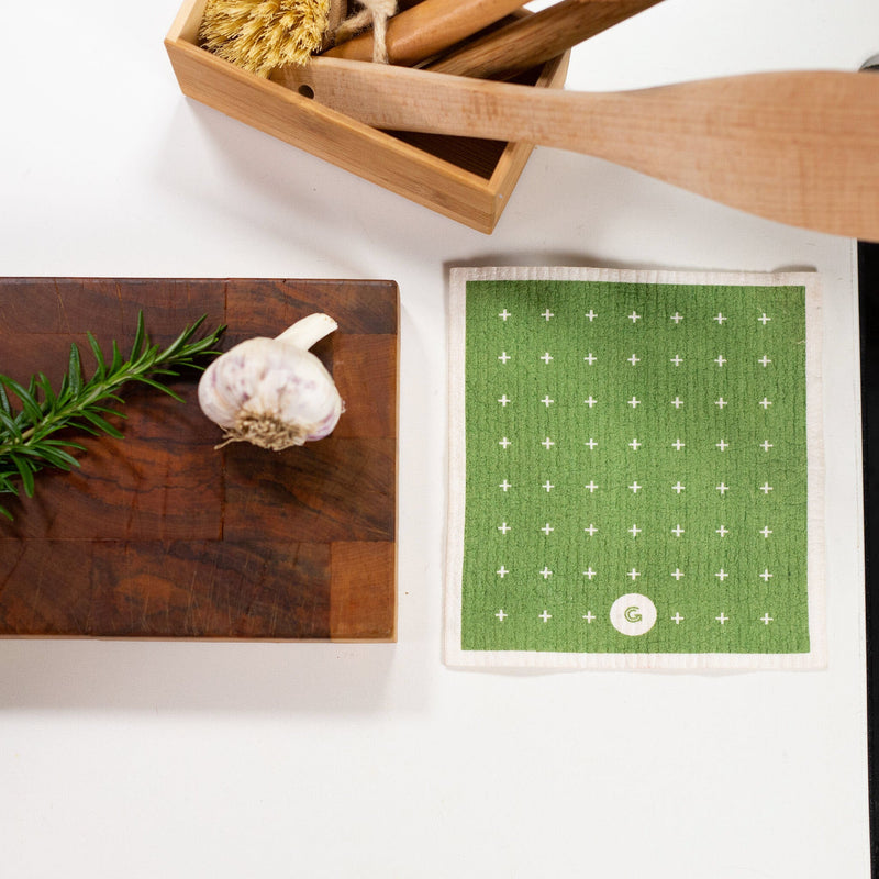 A Good Change ECO CLOTH - MEDIUM (3-PACK) with modern polka dot designs sits on a cutting board.