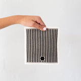 A person holding a Good Change ECO CLOTH - MEDIUM (3-PACK) featuring modern designs.