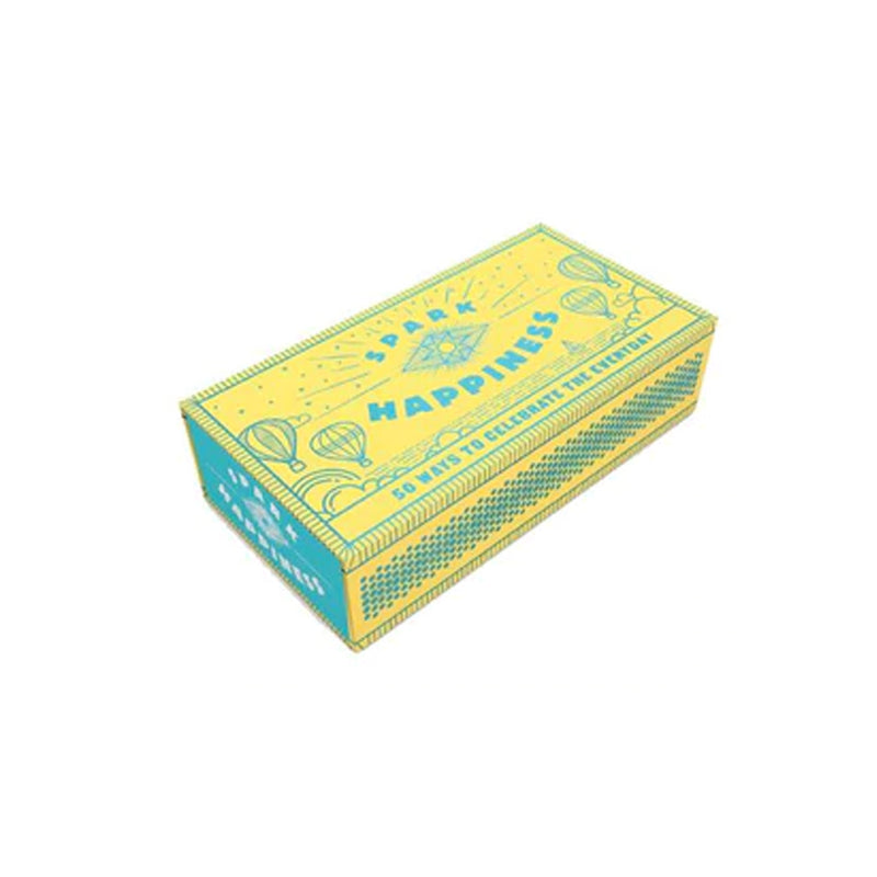 A box of Spark Happiness Wellness, decorated with a vibrant yellow and blue design, designed to spark moments of joy and happiness.