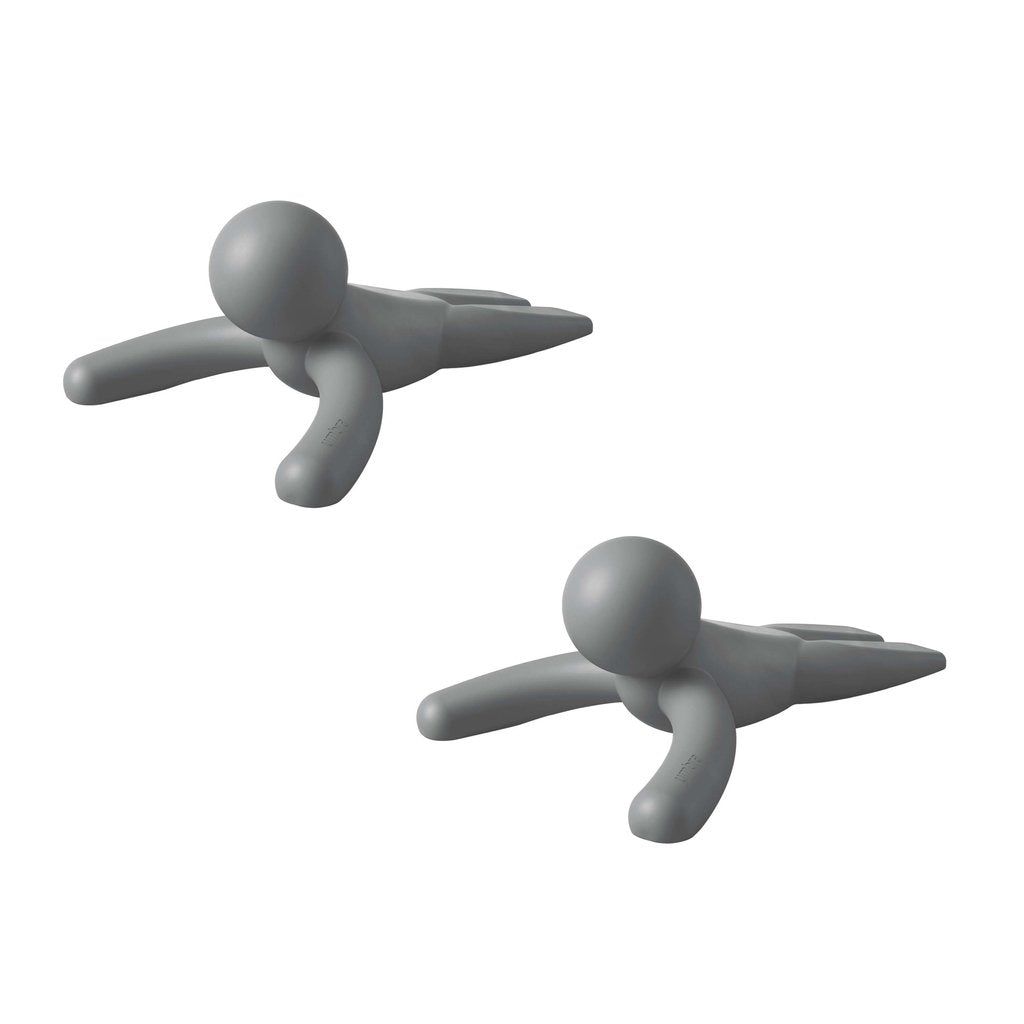 Two Umbra Buddy Doorstop Charcoal plastic figurines laying on top of each other.