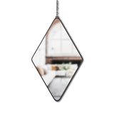 A decorative Dima Mirror Set of Three - Black hanging from a chain on a wall, made by Umbra.