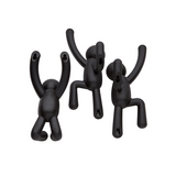 Three Umbra Buddy Hooks Black - Set of 3 hang on a white background, serving as adorable wall décor or playful coat hooks.