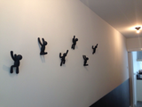 A hallway with a group of black Umbra Buddy Hooks Black - Set of 3 hanging on the wall.