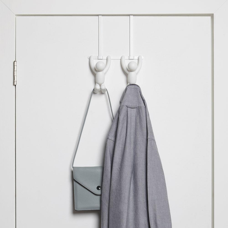 An Umbra Buddy Over-the-Door Hook Black, featuring a white coat hanger with a bag hanging on it.