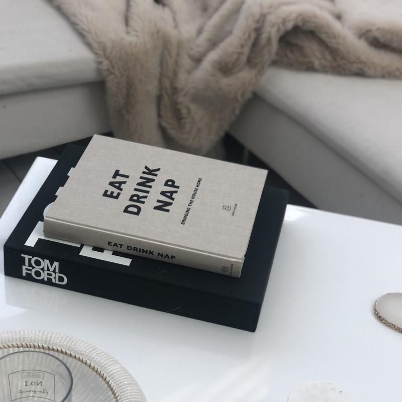 Eat, Drink, Nap book in a black slipcase on a marble table