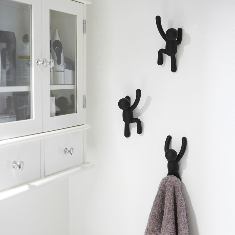 A bathroom with black Umbra Buddy Hooks - Set of 3 hanging on the wall.