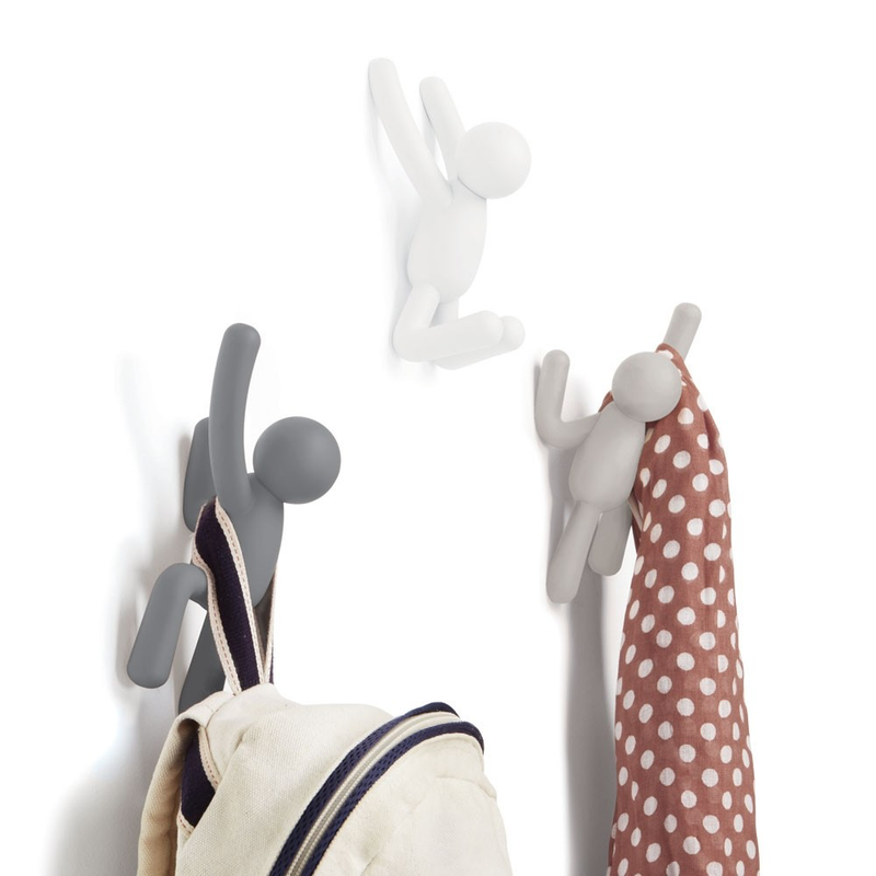 A group of durable molded polypropylene Buddy Hooks - Set of 3 Multi Grey from the Umbra range hanging on a wall with a polka dot bag.