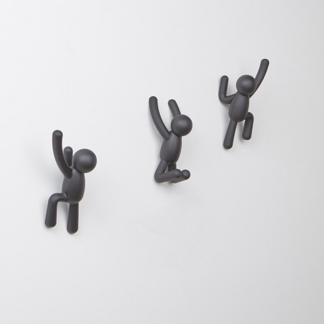 Three black Buddy Hooks transformed into wall décor, creating a unique coat rack with the Umbra Buddy Hooks Black - Set of 3.