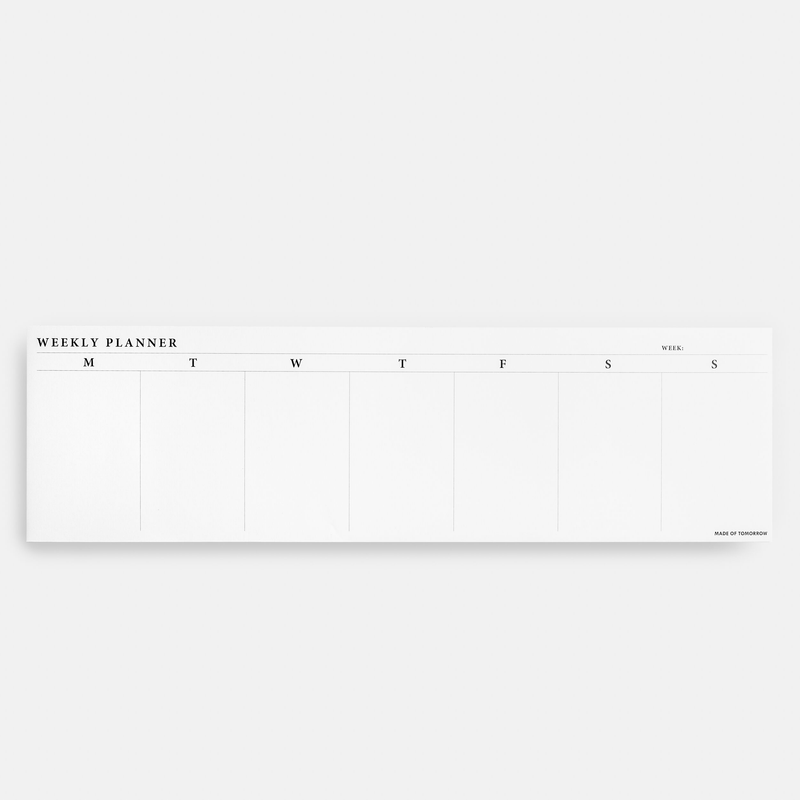 A white Weekly Desk Strip by Made of Tomorrow with the word 'weekly planner' written on it.