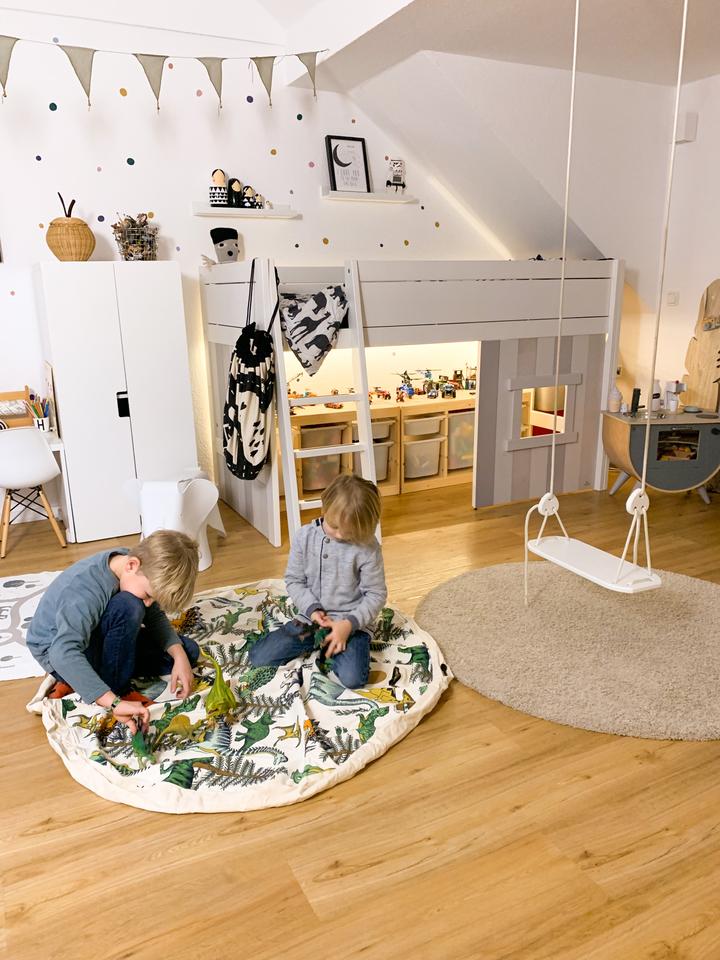 A Dino Raw Printed themed children's room with a wooden floor and a swing by Play Pouch.