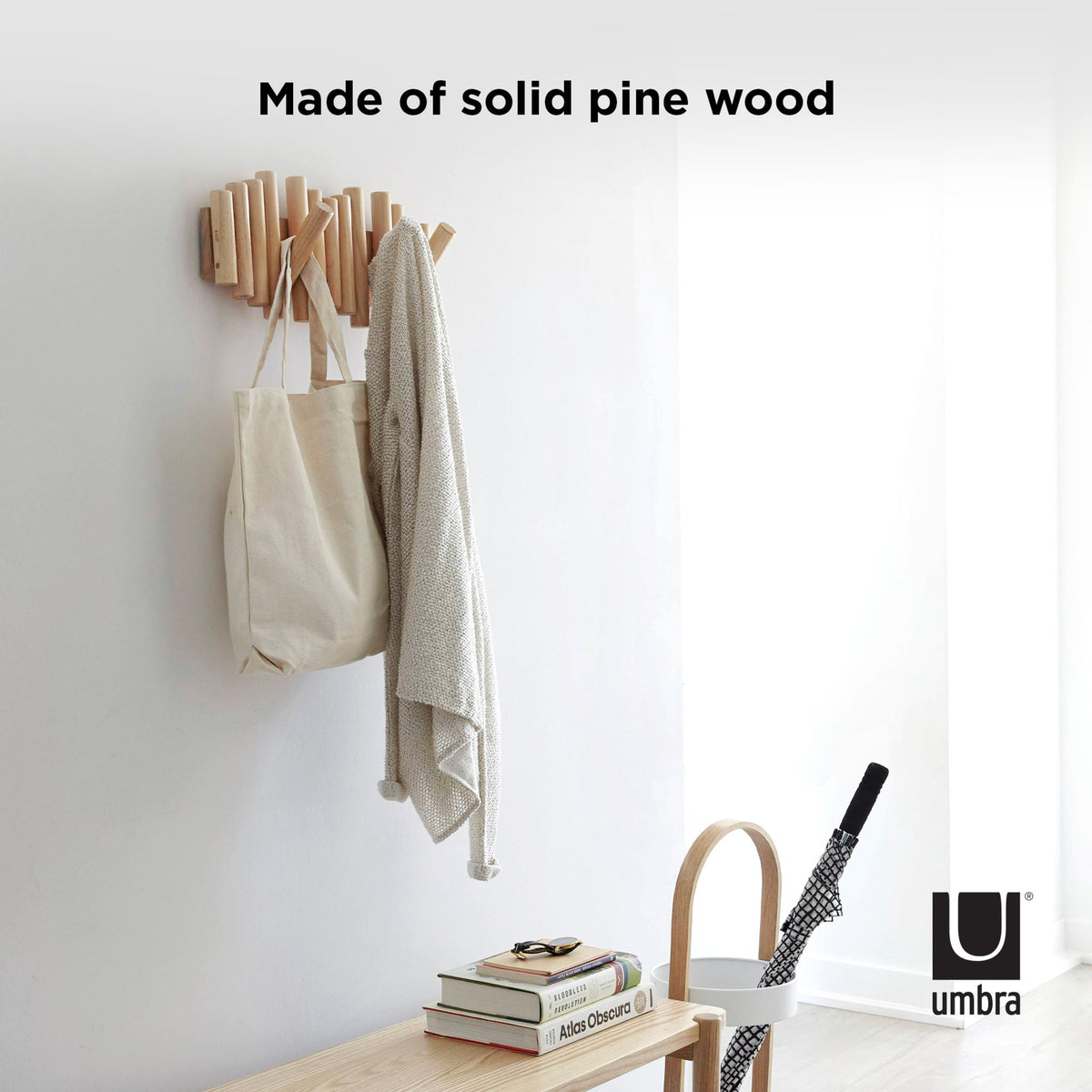 Pine Picket Rail on a white wall holding a tote and a jacket, captioned Made of solid pine wood