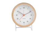 A white and orange Karlsson Alarm Innate - Various Colours alarm clock on a white stand.