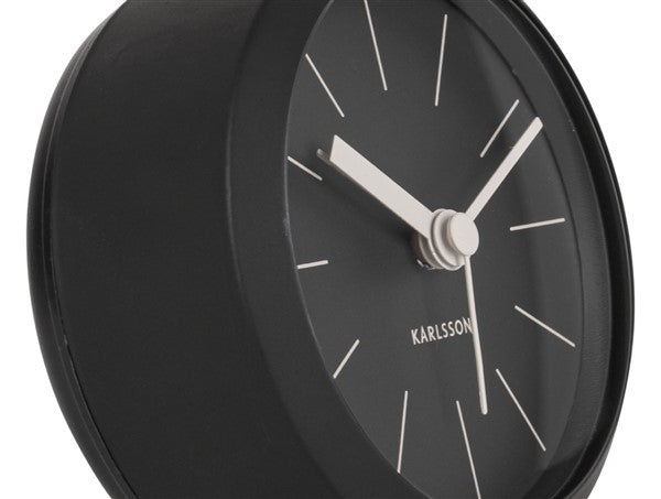 Close-up of the black Button alarm clock dial with white hands