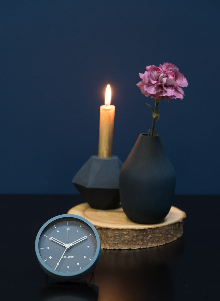 Aesthetic Karlsson alarm clock accompanies a candle on a Scandinavian table.