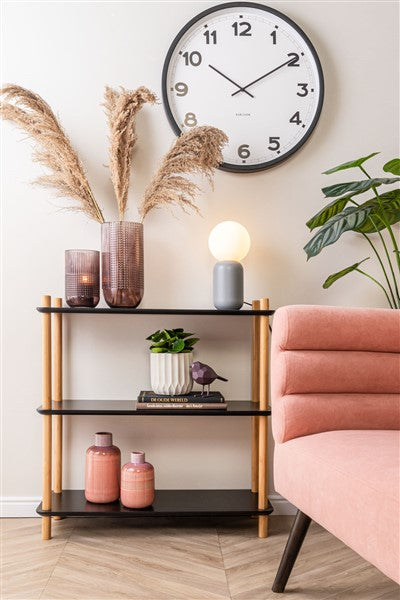 Karlsson New Classic wall clock on the wall of a Scandinavian living room with a pink sofa