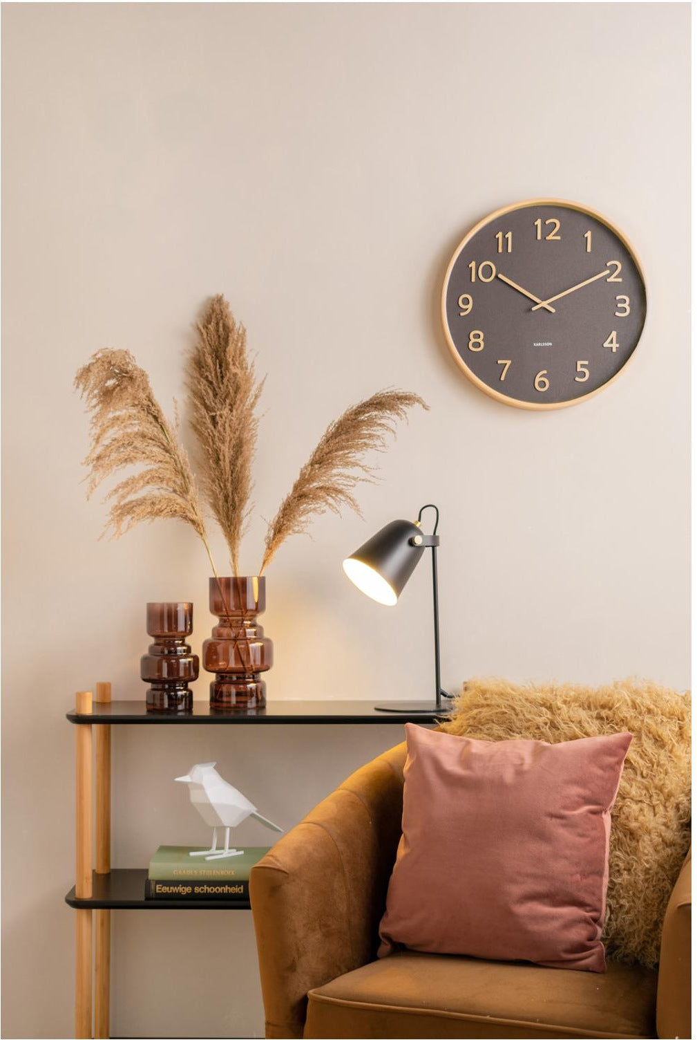 Karlsson Pure Wall Clock mounted on the wall of a living room with a brown armchair