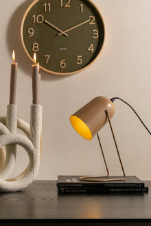 Karlsson Pure Wall Clock in moss green above a desk with a brass lamp and sculptural decor