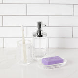 A bathroom with an Umbra Junip Tumbler - Acrylic soap dispenser and an Umbra Junip Tumbler - Acrylic filled with water.
