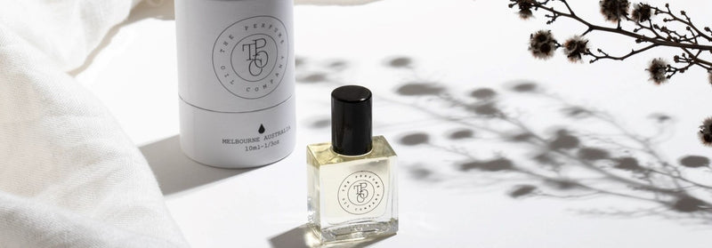 A bottle of The Perfume Oil Collection Gift Set - Fresh from The Perfume Oil Company sitting next to a white cloth.