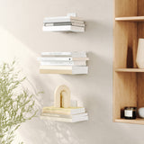 An Umbra Conceal 3 Pack - Silver, a space-saving shelf with invisible shelves for floating books and a plant.