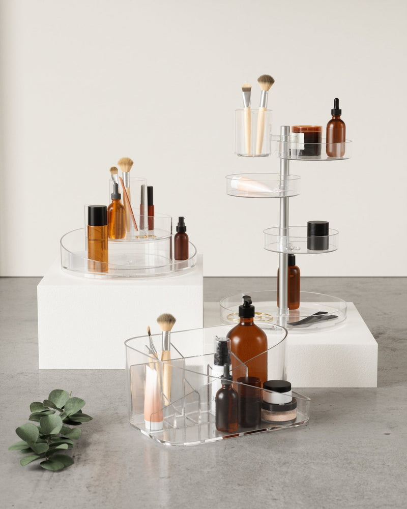 Three tiers of Cascada cosmetic organizers by Umbra on a table.