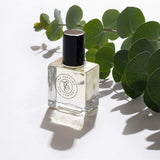 A bottle of ROUGE perfume oil, inspired by Baccarat Rouge 540 and scented with eucalyptus, placed on a white surface. (Brand Name: The Perfume Oil Company)