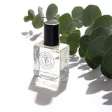 A eucalyptus perfume bottle on a white surface, perfect as a The Perfume Oil Collection Gift Set - Woody from The Perfume Oil Company.