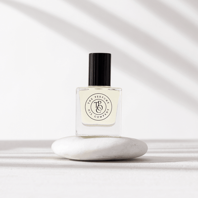 A WOODLAND roll-on perfume, inspired by Wonderwood (Comme des Garcon), from The Perfume Oil Company, with a fragrance collection sitting on top of a white stone.