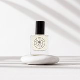 A bottle of The Perfume Oil Collection Gift Set - Fresh from The Perfume Oil Company sitting on top of a white stone, perfect for floral fragrance lovers and as a perfume oil gift set from The Perfume Oil Company.