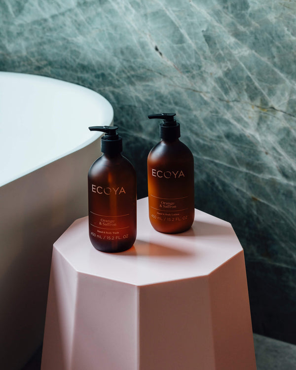 A limited edition Ecoya hand and body wash duo exudes a delightful fragrance, displayed on a chic pink stool.