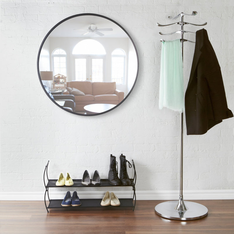 A modern shoe rack with an Umbra Hub Mirror 45cm Black and a pair of shoes.