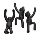 Three Buddy Hooks Black - Set of 3 plastic monkeys hanging on a white background, serving as unique wall décor or coat rack with Umbra hooks.
