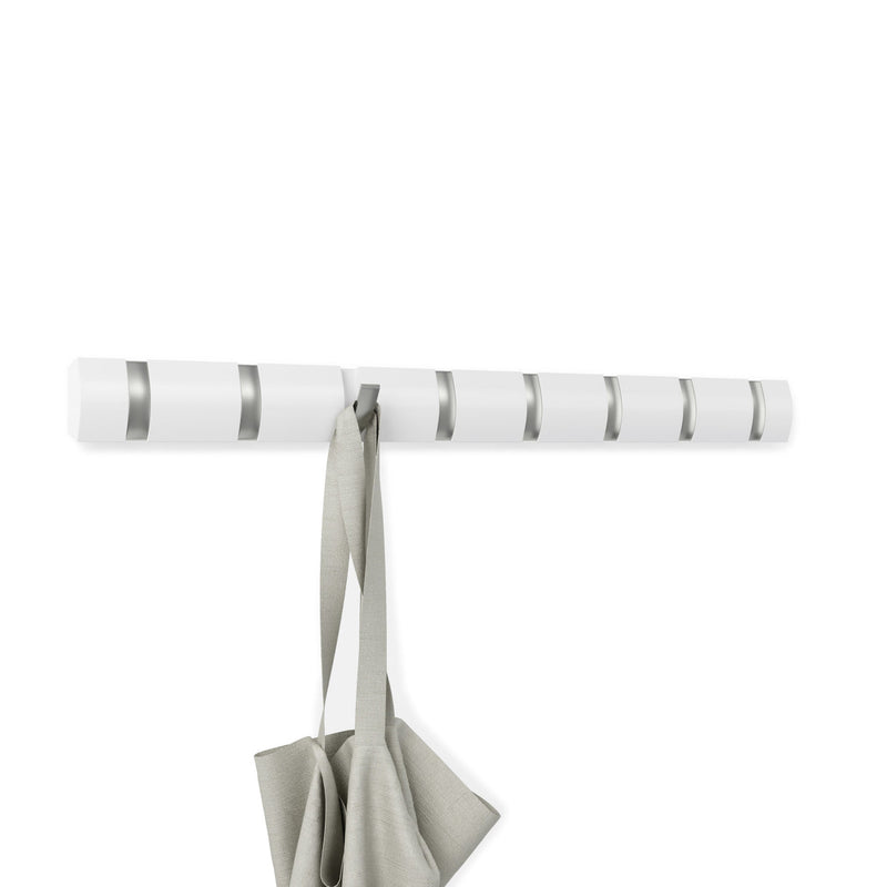 A Flip 8 Hook White coat rack from the Umbra range with retractable hooks, featuring a white color and a grey bag hanging on it.
