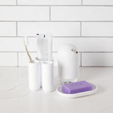 A bathroom with a sleek Touch Soap Dish by Umbra and toothpaste.