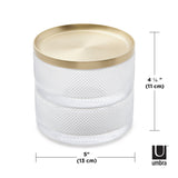 A modern design glass container with a gold lid, serving as a storage solution like the Umbra Tesora Storage Box.