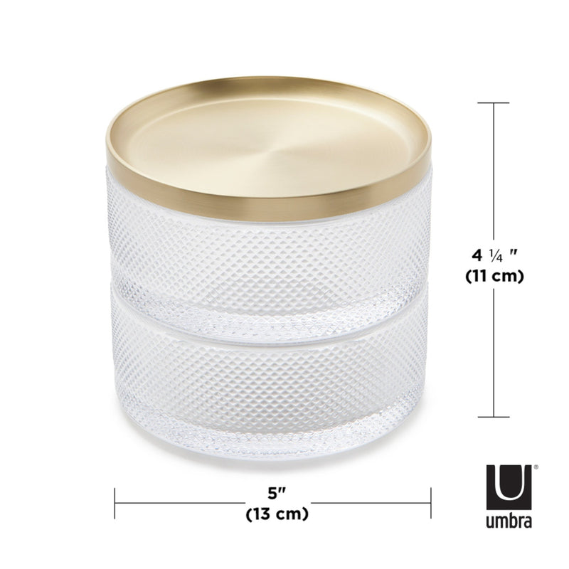 A modern design glass container with a gold lid, serving as a storage solution like the Umbra Tesora Storage Box.