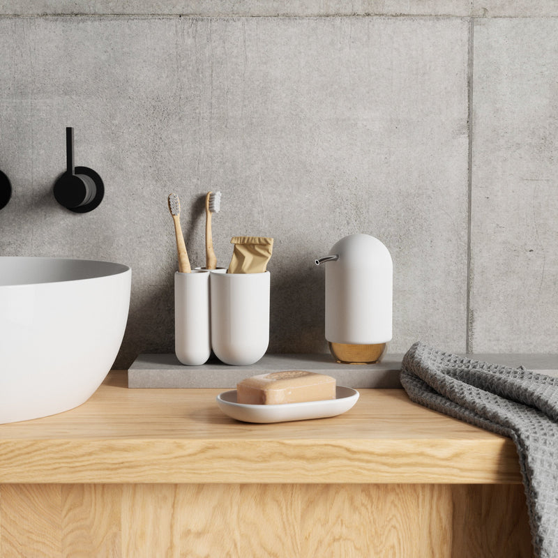 A bathroom with a sink, curved shape, and Umbra Touch Soap Dish.